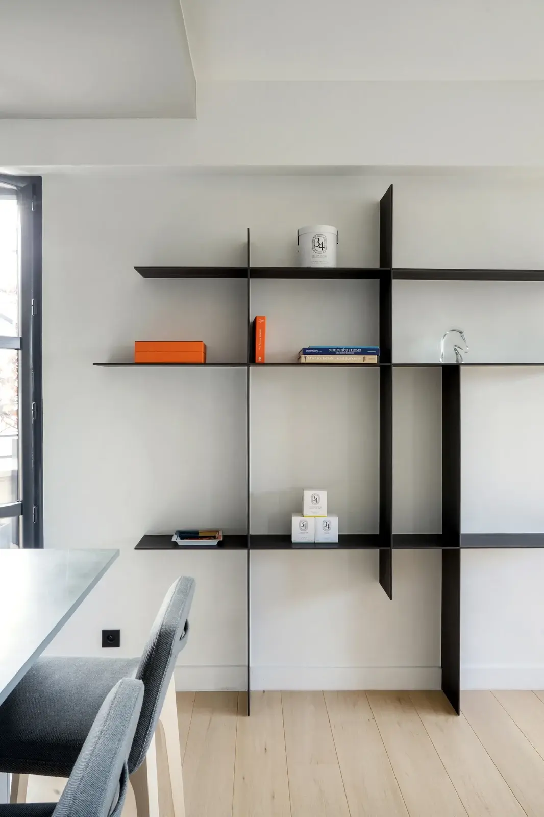 Projet CDG à Boulogne-Billancourt — bibliothèque en métal noir, composition orthogonale sur mur clair