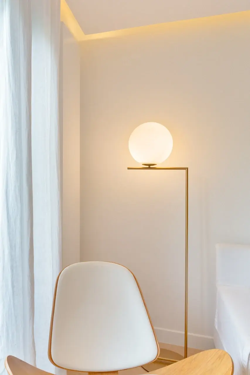 Projet Rebeval — lampadaire à globe opalin sur pied de laiton, rideau de lin et corniche lumineuse en plafond